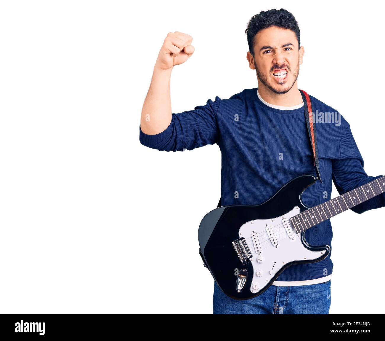 Un jeune hispanique jouant de la guitare électrique a énervé et frustré en criant avec colère, hurlant fou de colère et de main levée Banque D'Images