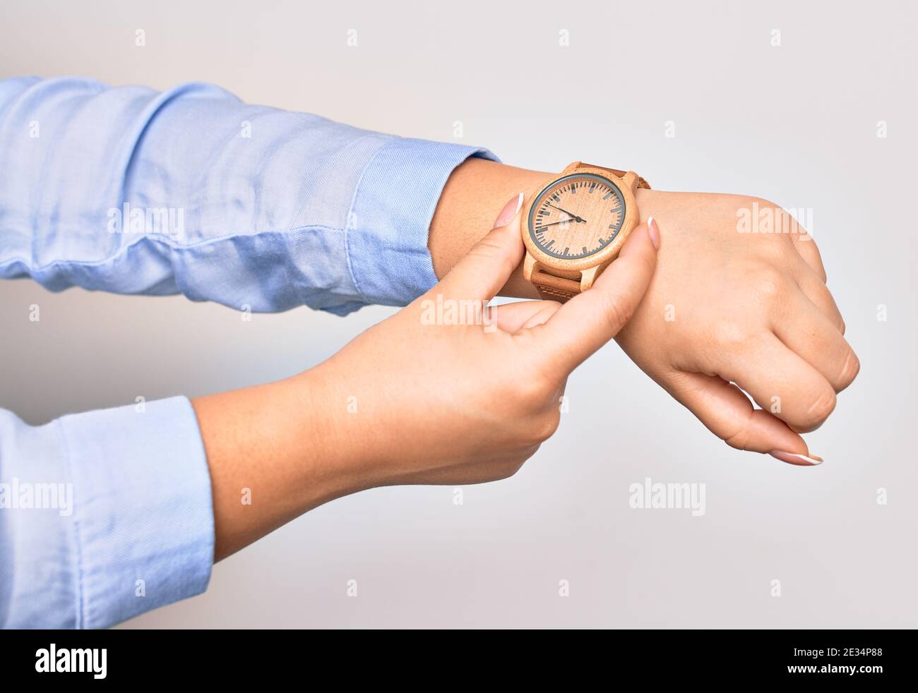 Main de la jeune femme d'affaires caucasienne portant une montre-bracelet.  Montre accrocheuse avec deux doigts sur un arrière-plan blanc isolé Photo  Stock - Alamy