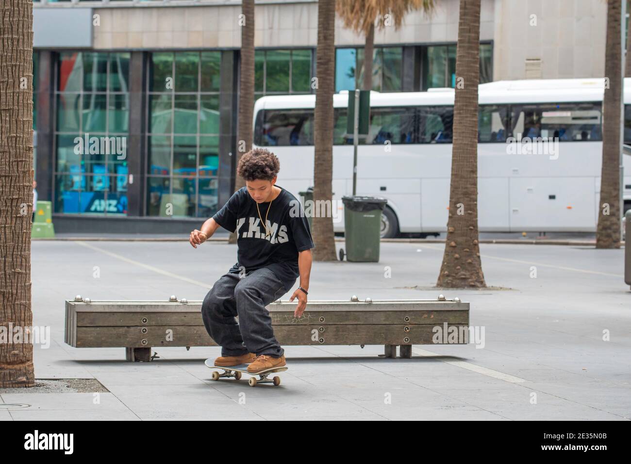 Un jeune coureur de skateboard australien effectue un flip ou une ollie sur un banc de bois à Sydney, en Australie (séquence 3 sur 3) Banque D'Images
