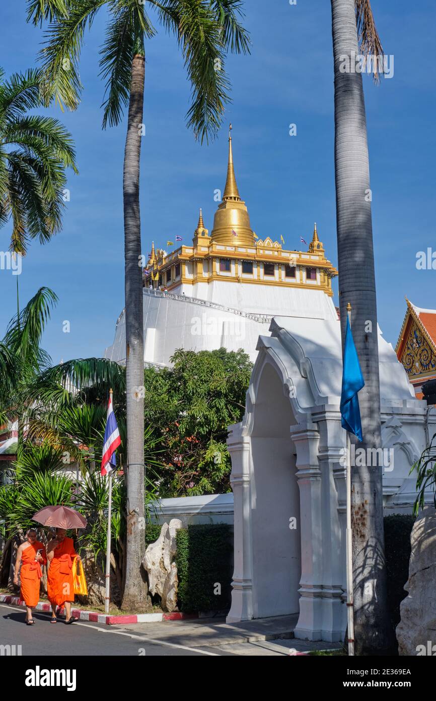 Moines bouddhistes dans le domaine tentaculaire de Wat Saket, Bangkok, Thaïlande, avec l'emblématique Mont d'Or (Phukhao Thong) en arrière-plan Banque D'Images