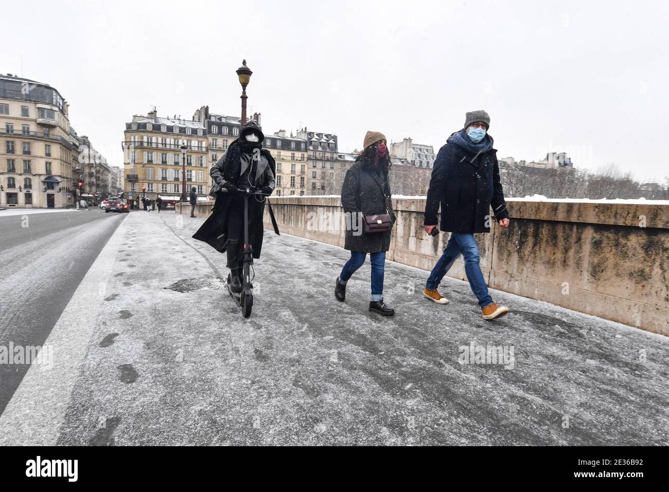 On voit des gens marcher dans les rues alors que la neige tombe à Paris, en France, le 16 janvier 2021. Meteo France a placé jeudi 10 départements dans le nord et l'est du pays en alerte météo orange en raison de prévisions de neige abondante. « ces chutes de neige se généraliseront et s'intensifieront au fil des heures dans les départements mis en alerte orange », a déclaré Meteo France. Photo de Lionel Urman/ABACAPRESS.COM Banque D'Images