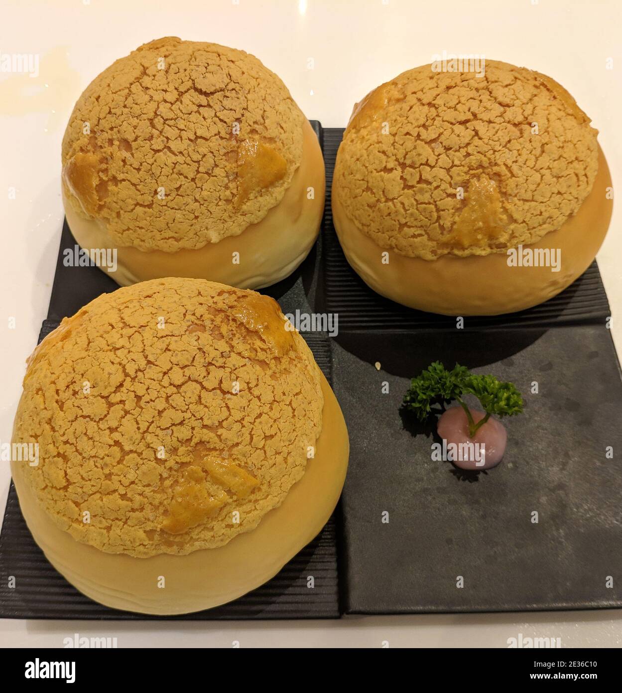 Trois pains croustillants aux ananas sur l'assiette noire pour manger Banque D'Images