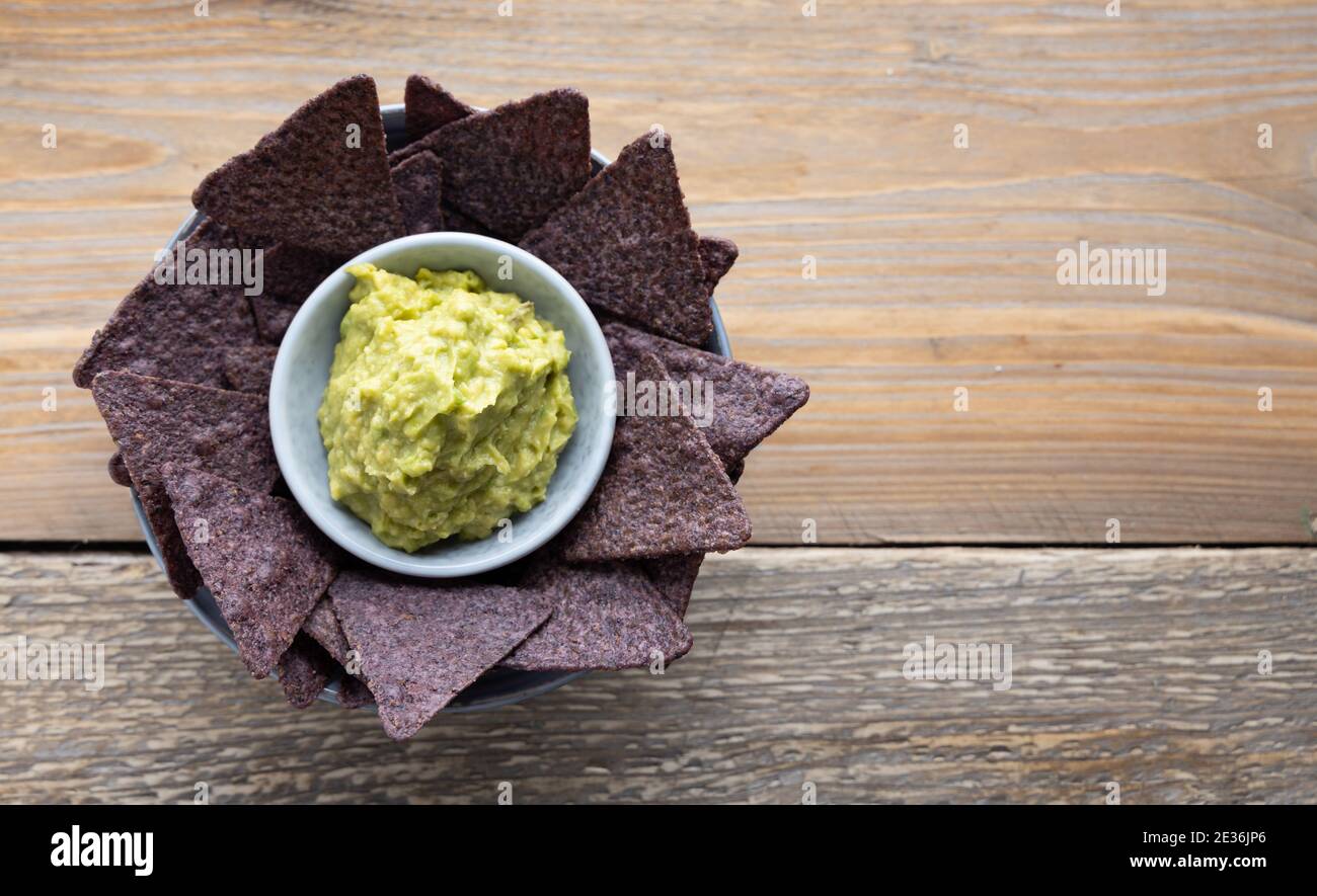 Chips de tortilla au maïs bleu avec guacamole maison sur le côté. Banque D'Images