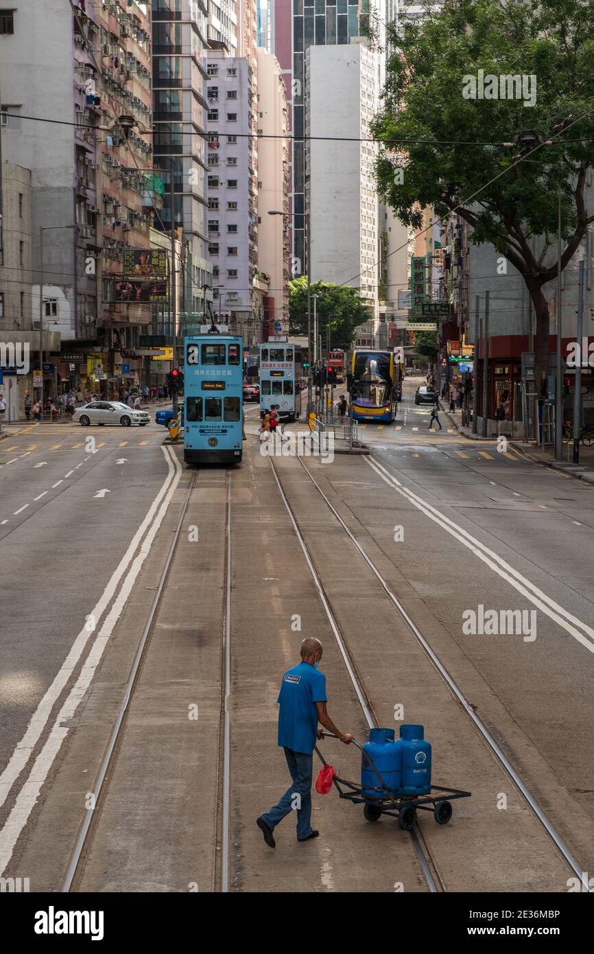 Un employé de la compagnie de gaz Shell livre des bidons de gaz aux clients sur Johnston Road à Wan Chai. Banque D'Images