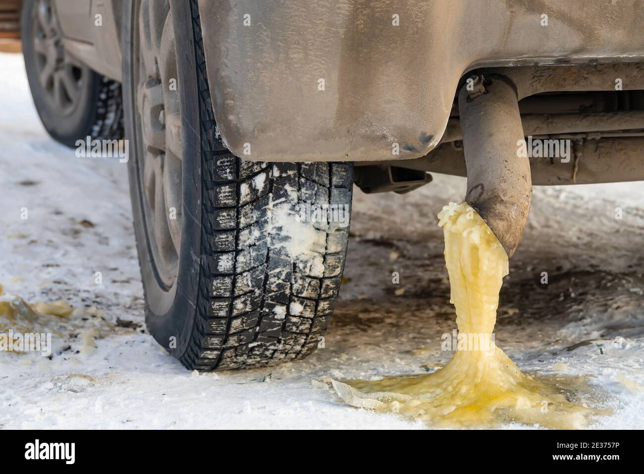 condensation d'eau jaune gelée avec de l'essence provenant du tuyau  d'échappement d'une voiture sur la neige en hiver froid saison Photo Stock  - Alamy