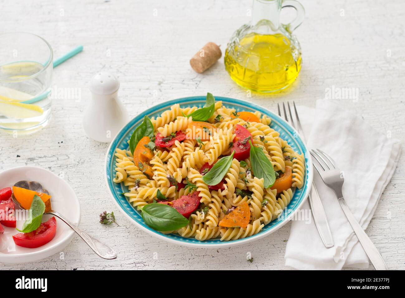 Pâtes d'été avec tomates, herbes et huile d'olive sur fond clair. Une alimentation saine et délicieuse Banque D'Images