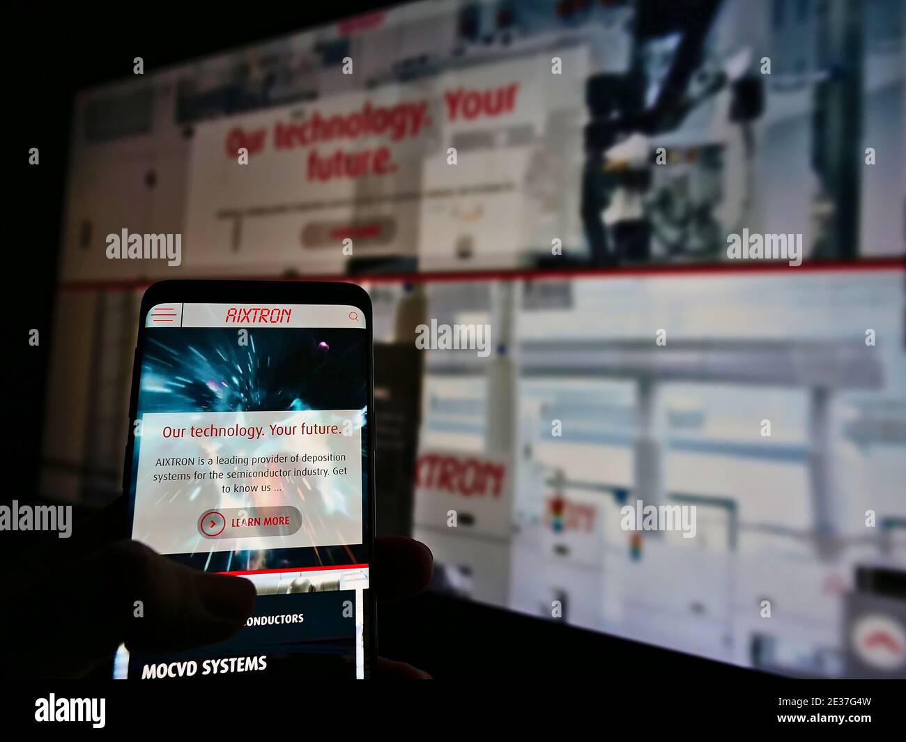 Personne parcourant le site Web de la société allemande de technologie Aixtron se dans l'industrie des semi-conducteurs. Mise au point sur l'écran du smartphone. Photo non modifiée. Banque D'Images