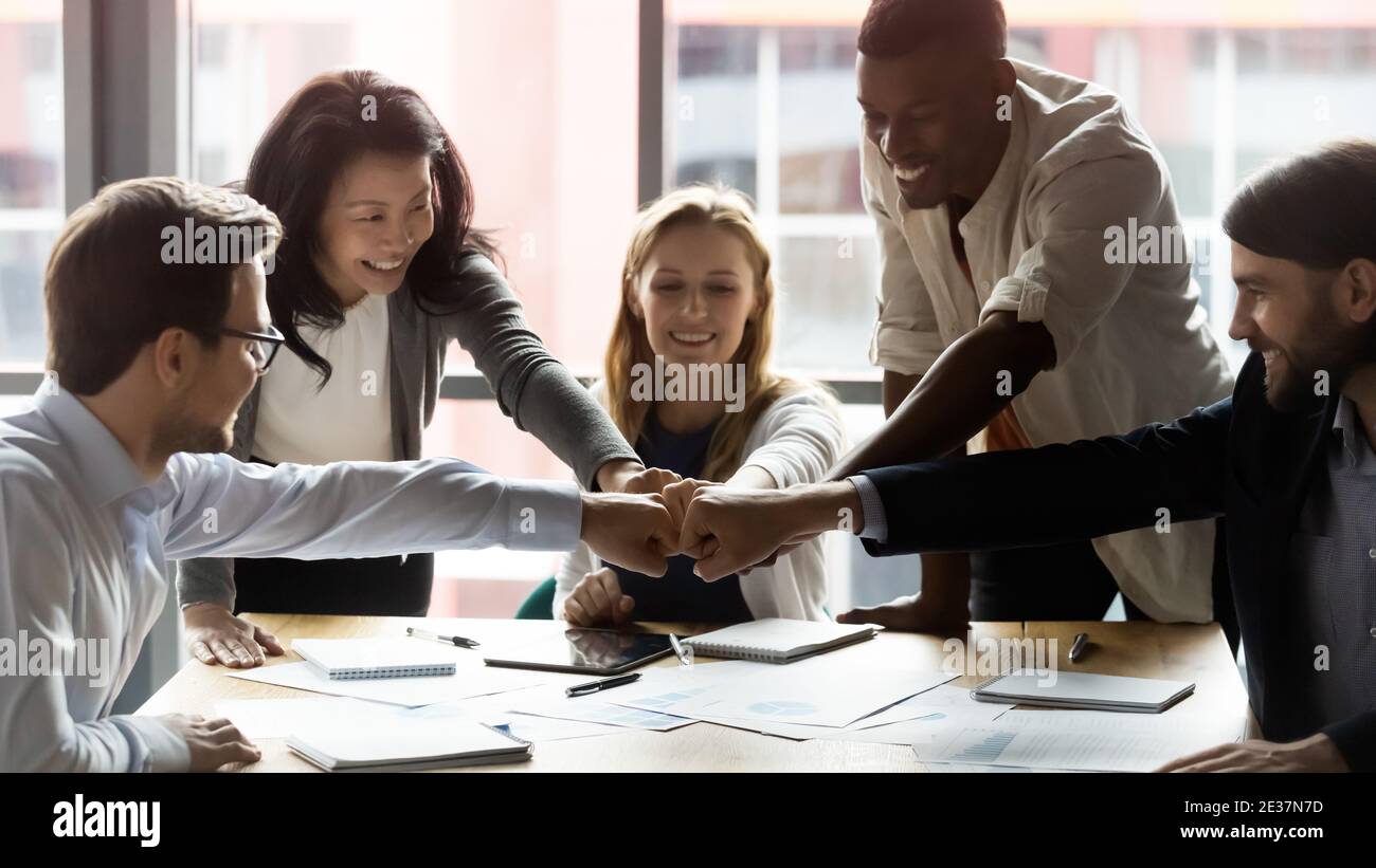 Des gens d'affaires multiraciaux heureux, jeunes et plus âgés, qui font preuve d'esprit d'équipe. Banque D'Images