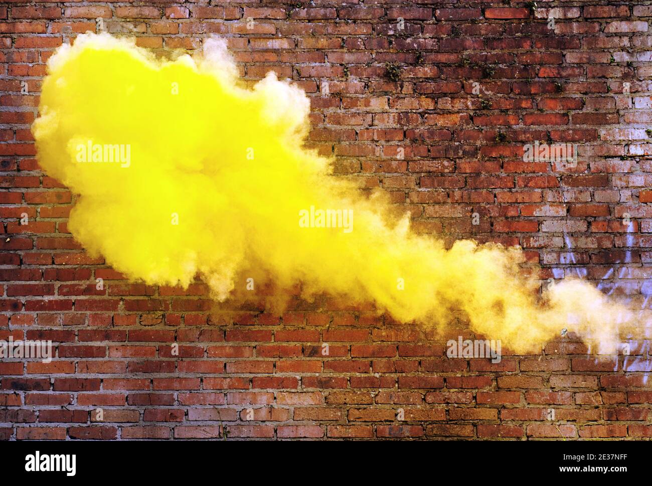 Fumée jaune dense sur le fond rouge de mur de brique Banque D'Images