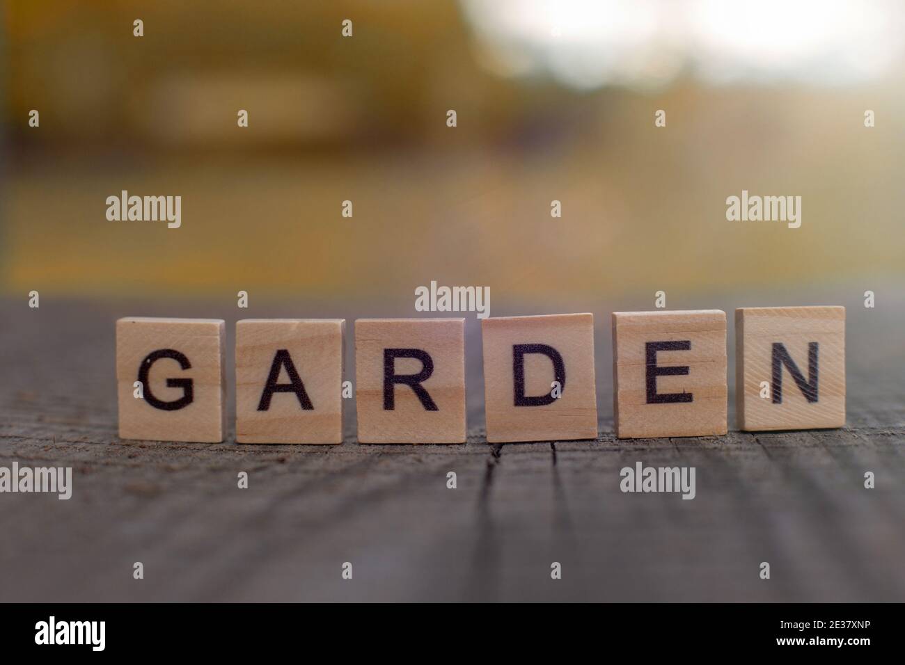 Lettre en bois dans le mot jardin, stands d'une table en bois gris avec une vue sur le paysage d'automne Banque D'Images