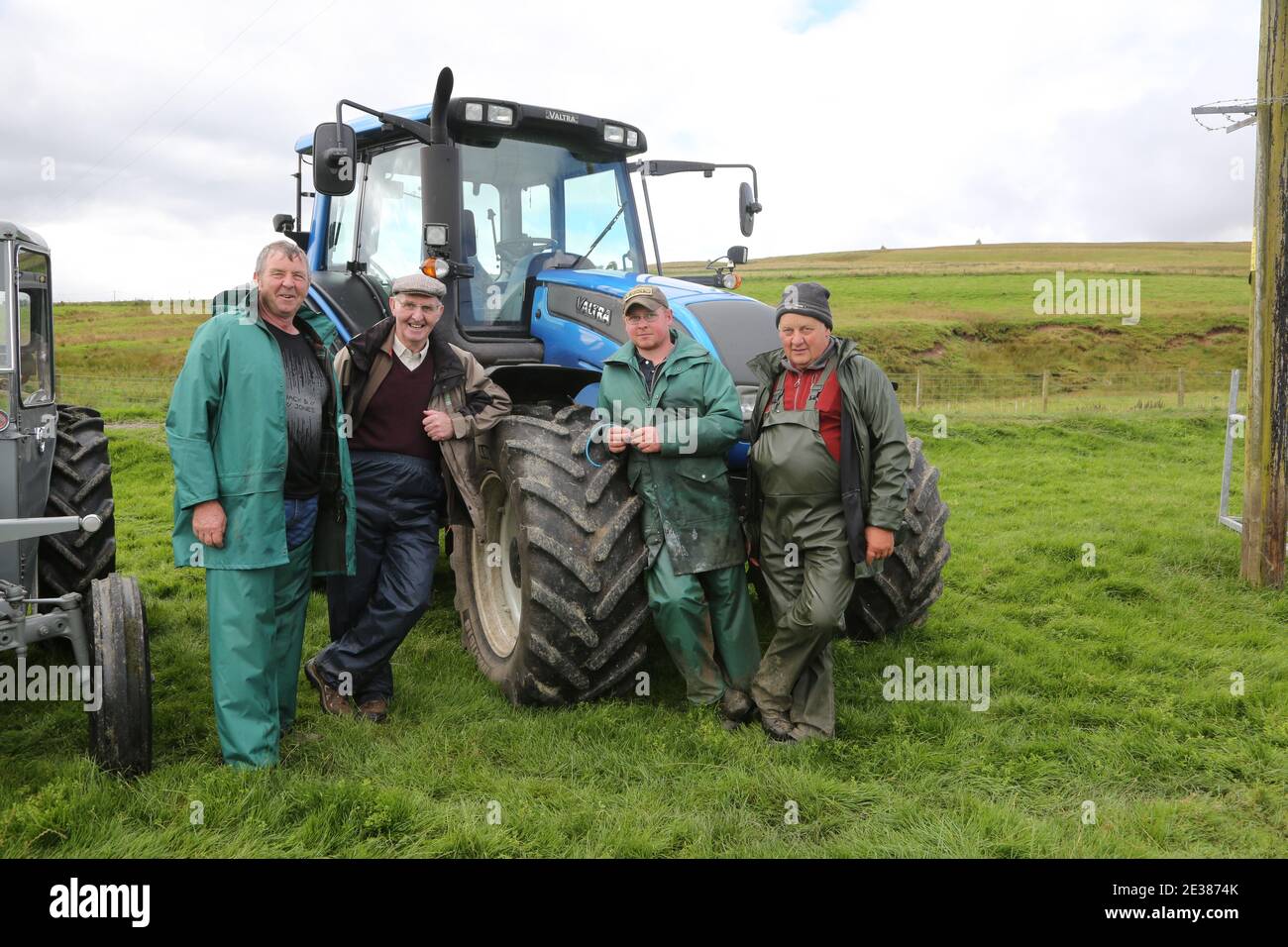 Muirkiirk, East Ayrshire, Écosse, Royaume-Uni, salon agricole du village, les agriculteurs locaux et leurs familles rencontrent et rivalisent avec le bétail, les moutons et le bétail sur le displayAu groupe d'agriculteurs admirent les tracteurs anciens et nouveaux Banque D'Images