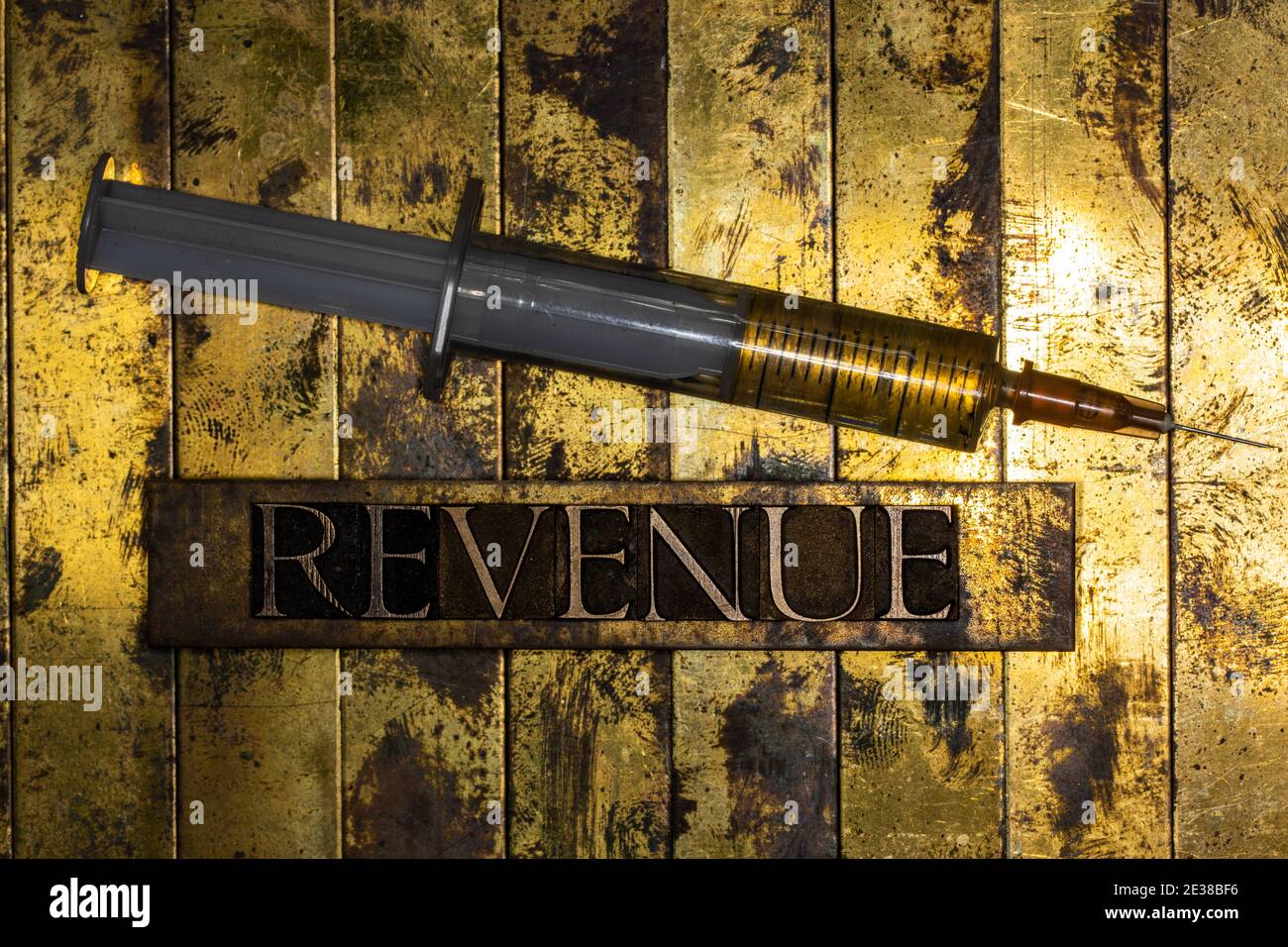 Texte de recettes à côté de la seringue remplie de liquide sur le grunge fond texturé en cuivre et or Banque D'Images