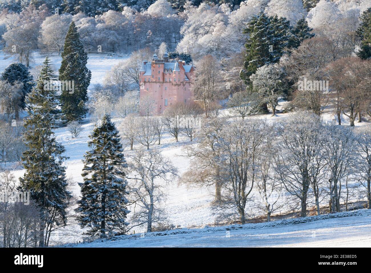 Château de Craigievar niché au milieu des arbres sur une forêt enneigée Hillside en Écosse Banque D'Images