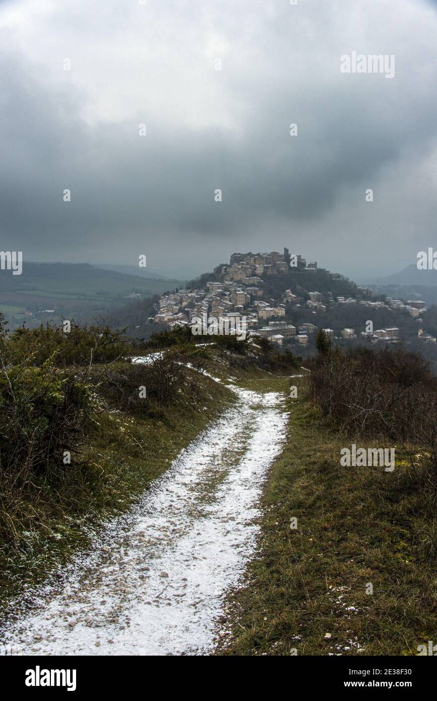 Une vue portrait d'un sentier sinueux avec une couverture de neige légère, menant au village médiéval de cordes-sur-ciel, au sommet d'une colline, dans le sud de la France. Banque D'Images