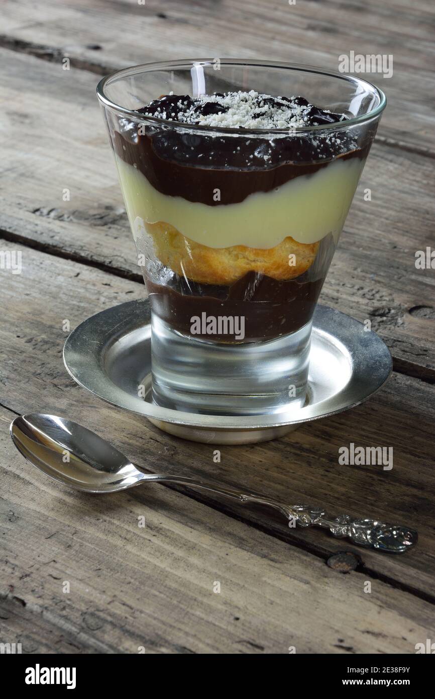Dessert à la profiterole en verre et cuillère sur une table rustique Banque D'Images