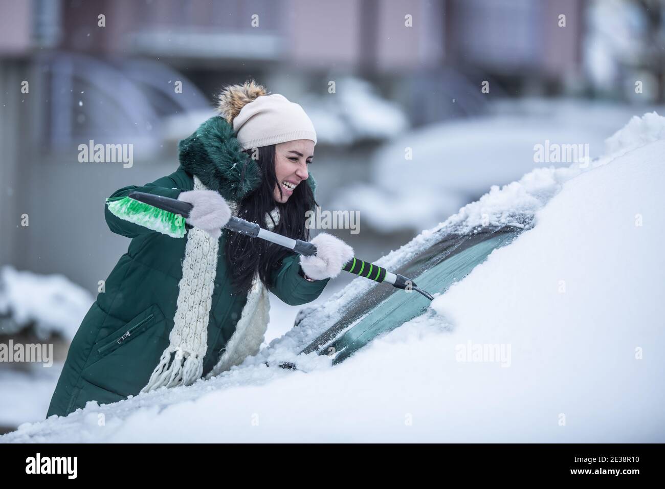 Travail dur raclant les pare-brise de la voiture de la glace et de la neige pendant un hiver froid. Banque D'Images