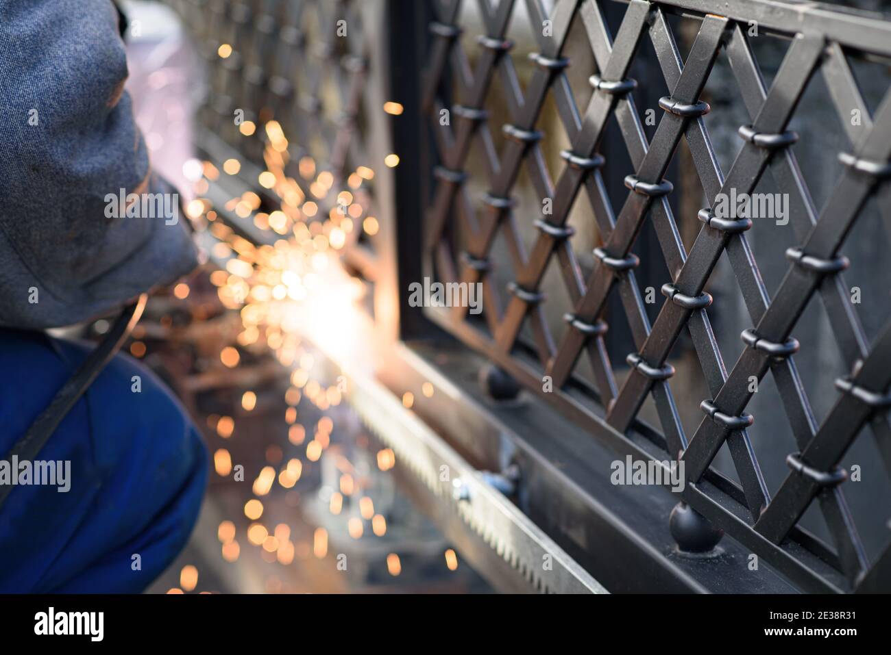 Soudage des supports d'engrenages en acier à la porte. Dernière phase avant la configuration d'un opérateur de grille automatique. Service professionnel d'installation et de maintenance de Banque D'Images