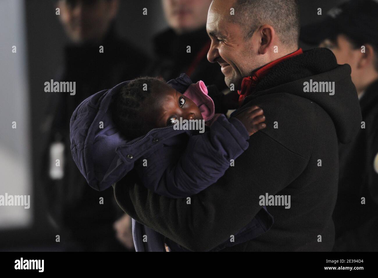 Le père adoptif français quitte avec son enfant d'Haïti, l'aéroport Charles de Gaulle-Roissy, à l'extérieur de Paris, Fran le 22 décembre 2010, après leur arrivée sur un avion nolisé par le gouvernement français transportant 114 enfants haïtiens de Port-au-Prince. Un total de 318 enfants haïtiens adoptés sont inclus dans un programme spécial pour les amener en France après les perturbations causées par le tremblement de terre dévastateur qui a ravagé le pays appauvri il y a près d'un an. Photo de Mousse/ABACAPRESS.COM Banque D'Images