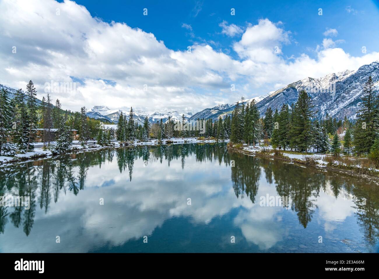 Parc national Banff magnifique paysage naturel en hiver ensoleillé. Mont Norquay avec ciel bleu, nuages blancs réfléchis sur la rivière Bow comme un miroir Banque D'Images