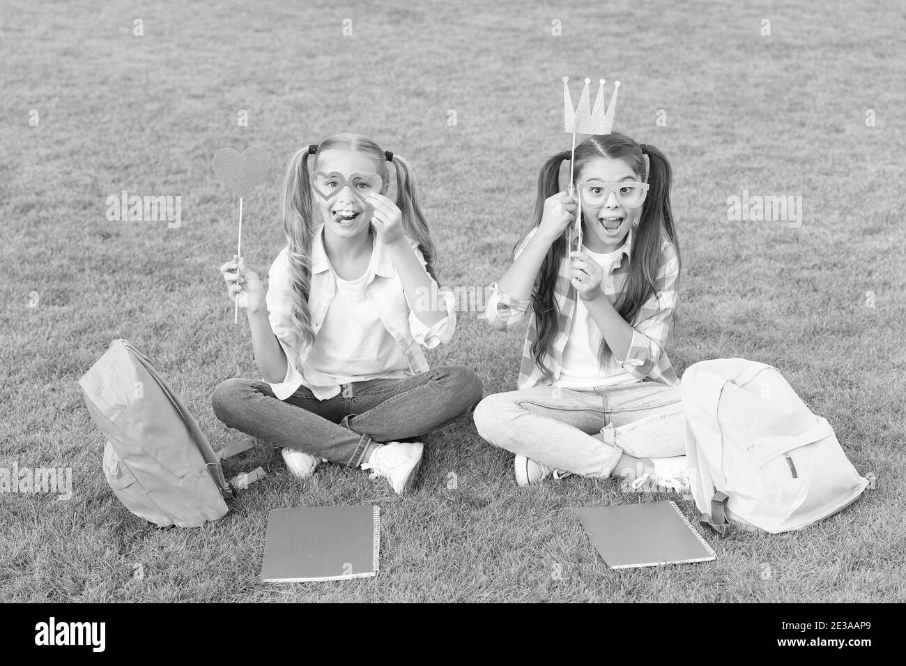 Détente ensemble. Concept de famille et de sistesité. Journée de la connaissance. S'amuser avec les attributs de la fête. Deux petits enfants avec sac à dos. Petite fille joue et étudie pendant les vacances scolaires. Bonne journée pour les enfants. Banque D'Images