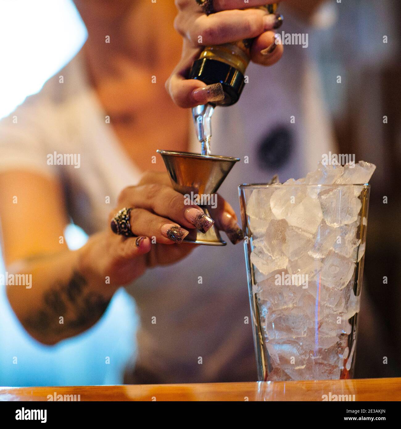 serveur barman mélangeant verser un cocktail de boissons mélangées derrière le bar Banque D'Images