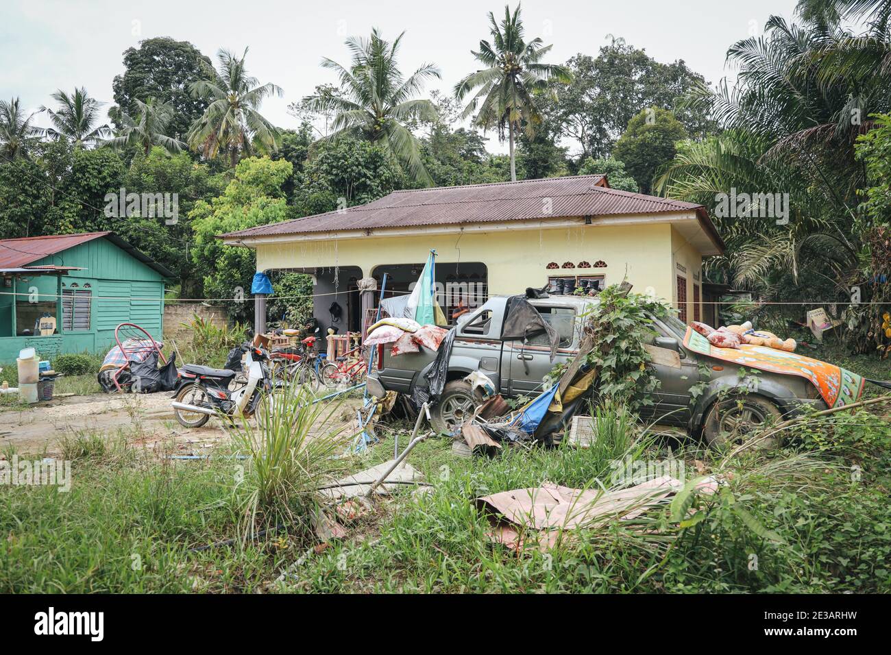 Kampung Ajai, Malaisie. 17 janvier 2021. Une femme la ferme alors que les meubles laissés sécher à l'extérieur de sa maison suite à une inondation à Kampung Ajai.inondations en Malaisie causées par de fortes pluies de mousson affectent la plupart de la Malaisie péninsulaire. Crédit : SOPA Images Limited/Alamy Live News Banque D'Images