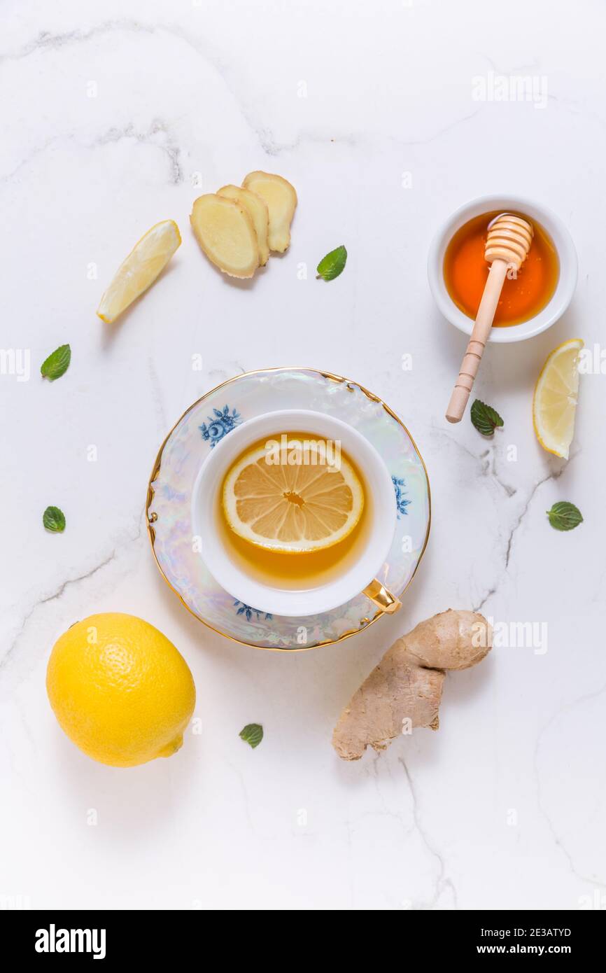 Thé avec citron, gingembre et miel comme médecine naturelle sur fond blanc Banque D'Images