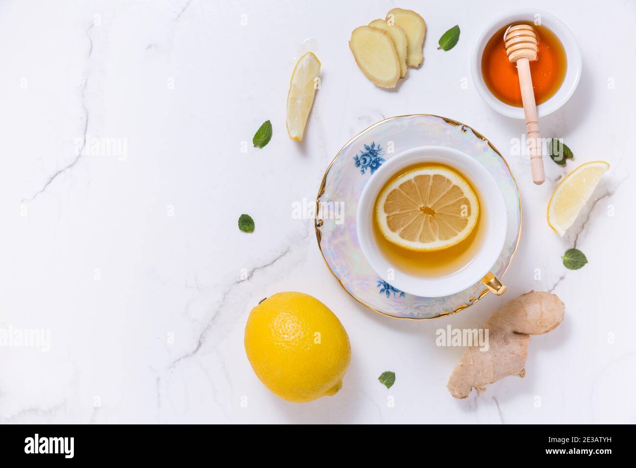 Thé avec citron, gingembre et miel comme médecine naturelle sur fond blanc Banque D'Images