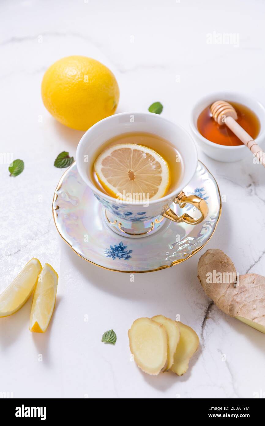 Thé avec citron, gingembre et miel comme médecine naturelle sur fond blanc Banque D'Images