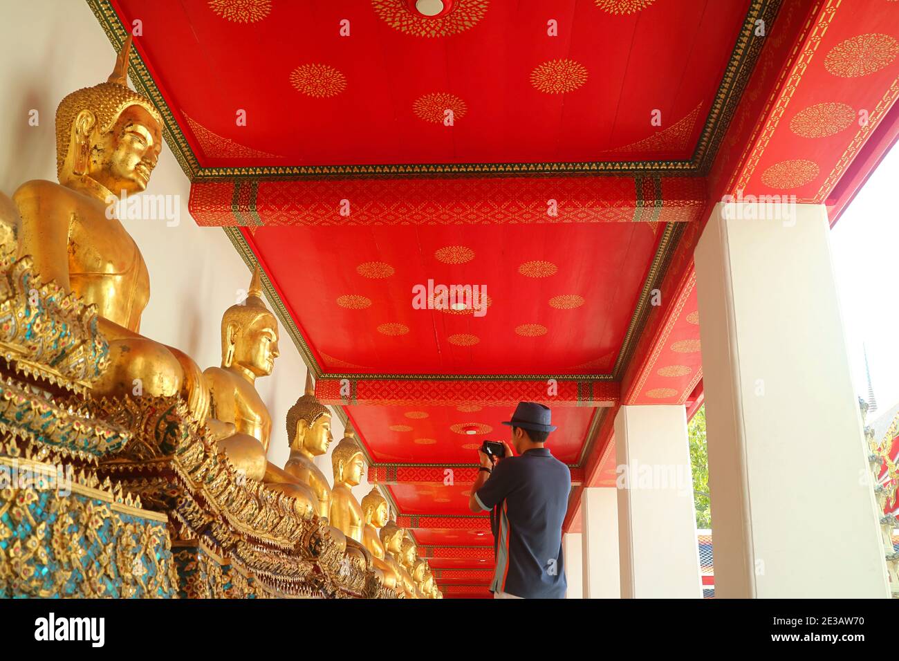 Visiteur prenant des photos du groupe d'images de Bouddha assis dans le cloître de Wat Pho ou le temple du Bouddha couché, Bangkok, Thaïlande Banque D'Images