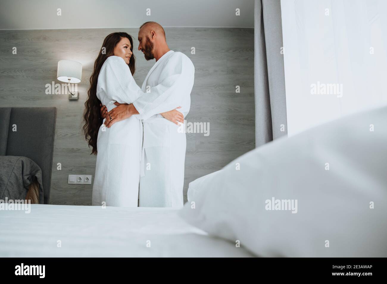 Un couple amoureux, vêtu de robes blanches, regarde tendinement les uns