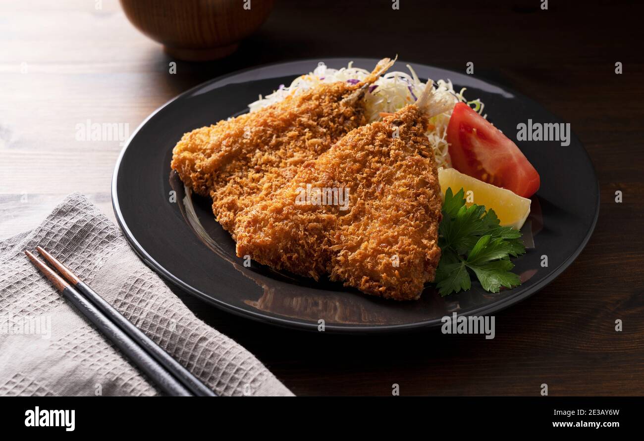 Le chinchard frit servi sur une assiette sur fond de bois. Cuisine japonaise maison Banque D'Images