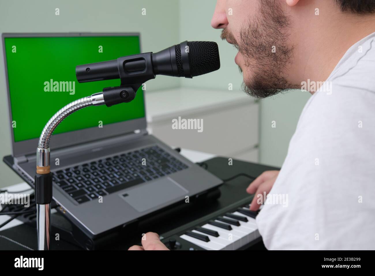 Homme méconnu blogueur, youtuber, influenceur enregistrant une vidéo jouant le piano électronique et chantant à la maison. Musicien, chanteur, pianiste. G Banque D'Images