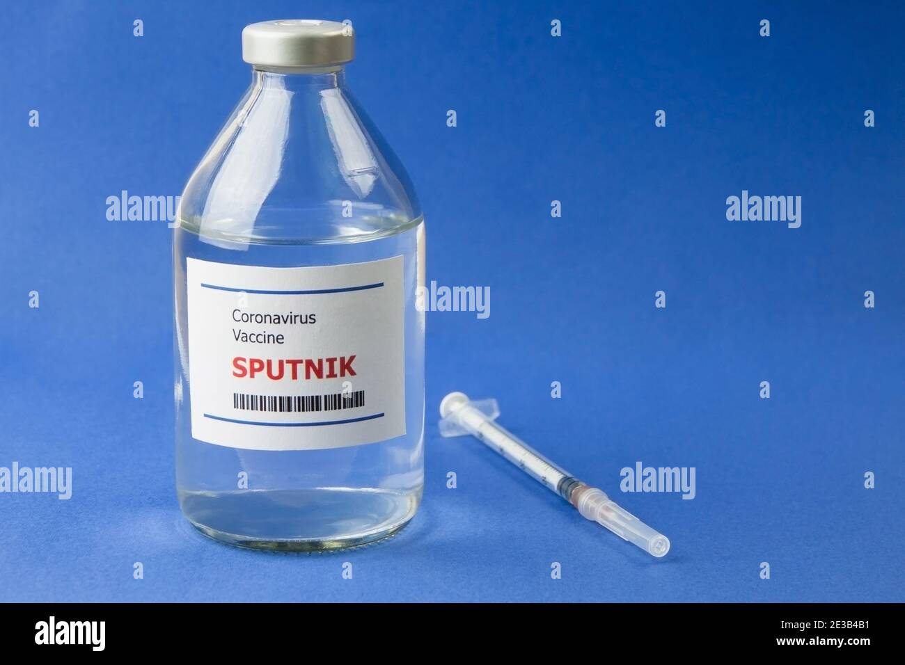 Krasnodar, Russie - 12 janvier 2021 : une bouteille de vaccin Spoutnik de Covid-19 et une seringue sur fond bleu Banque D'Images