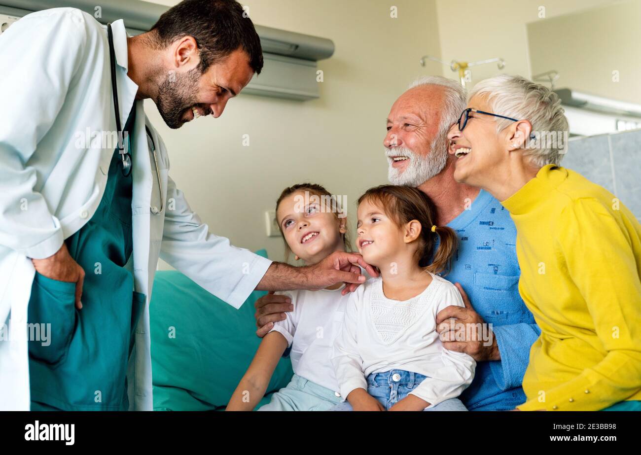 Famille rendant visite à un homme mature à l'hôpital. Santé, retraité, concept de soutien familial Banque D'Images