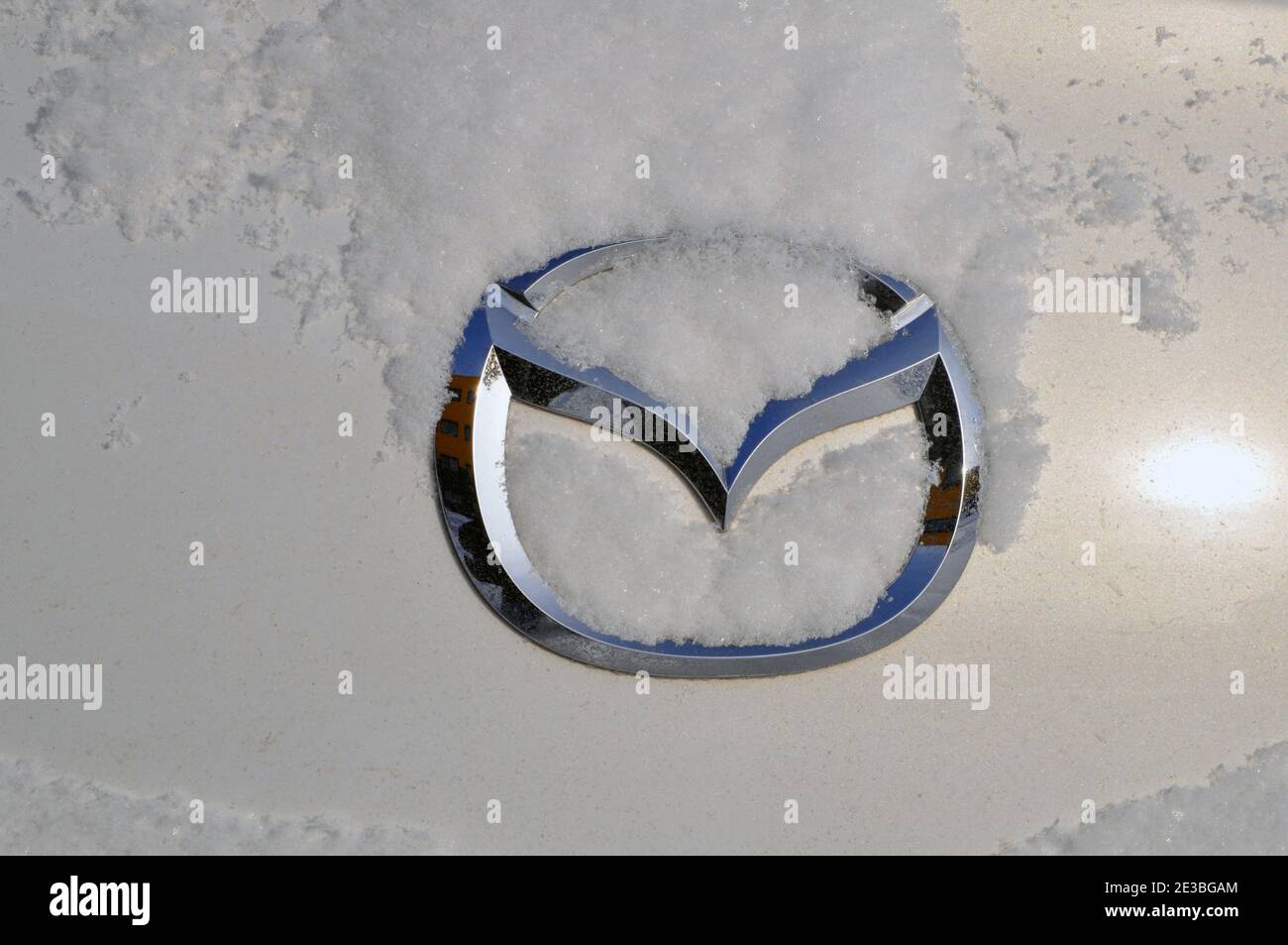 Logo Mazda sur le couvercle du coffre sous une couche de neige. Hiver. Banque D'Images
