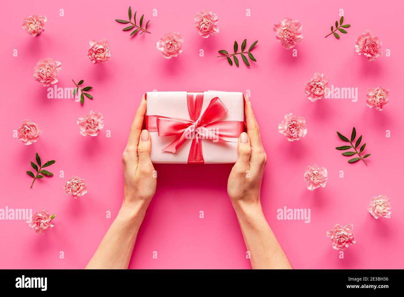Boîte cadeau rouge entre les mains des femmes - célébration de la Saint-Valentin. Vue de dessus Banque D'Images