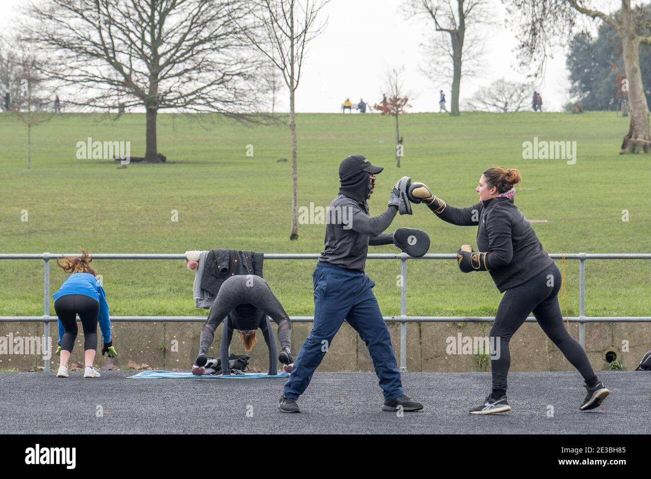 Un homme et une femme qui suivent un entraînement de boxe et une femme restent en forme à Brockwell Park le 15 janvier 2021 dans le sud de Londres, en Angleterre. Photo de Sam Mellish Banque D'Images
