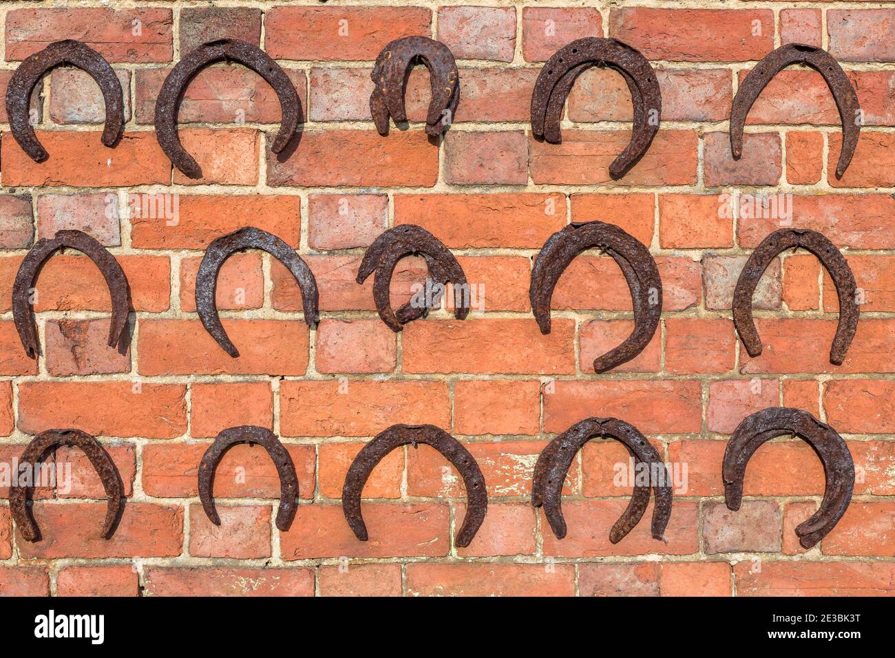 Fers à cheval suspendus sur un mur de briques, fond de chaussures de cheval, Royaume-Uni Banque D'Images