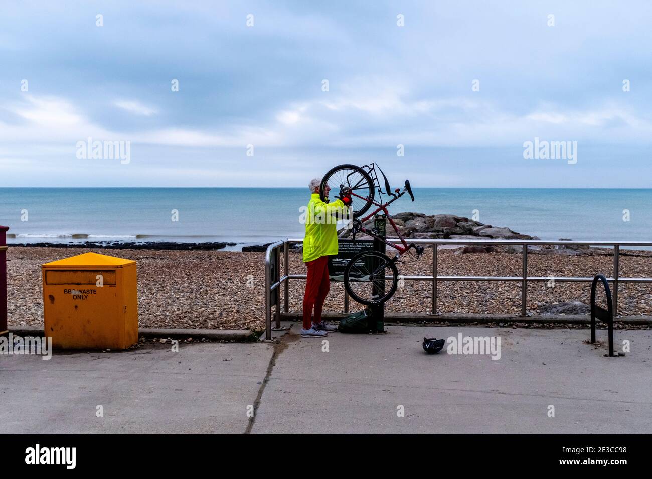 Cycliste en réparation de son vélo, Rotingdean près de Brighton, East Sussex, Royaume-Uni. Banque D'Images