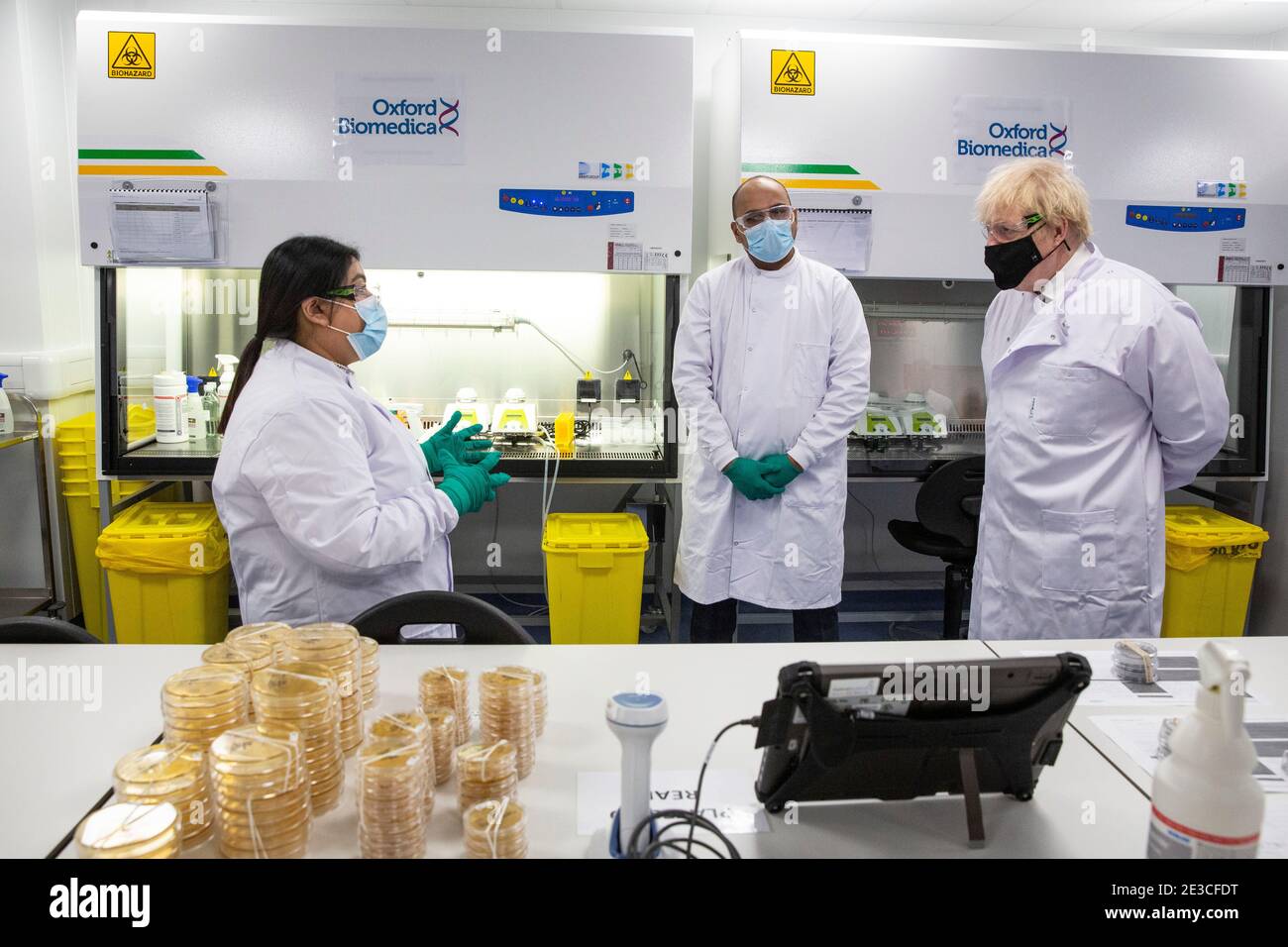 Le Premier ministre Boris Johnson s'entretient avec Dipesh Sonar (au centre) et Nisha Gill dans le laboratoire de contrôle de la qualité, où des lots de vaccins sont testés, lors d'une visite de l'usine de fabrication du vaccin Oxford/AstraZeneca à Oxford Biomedica dans l'Oxfordshire. Date de la photo: Lundi 18 janvier 2021. Banque D'Images