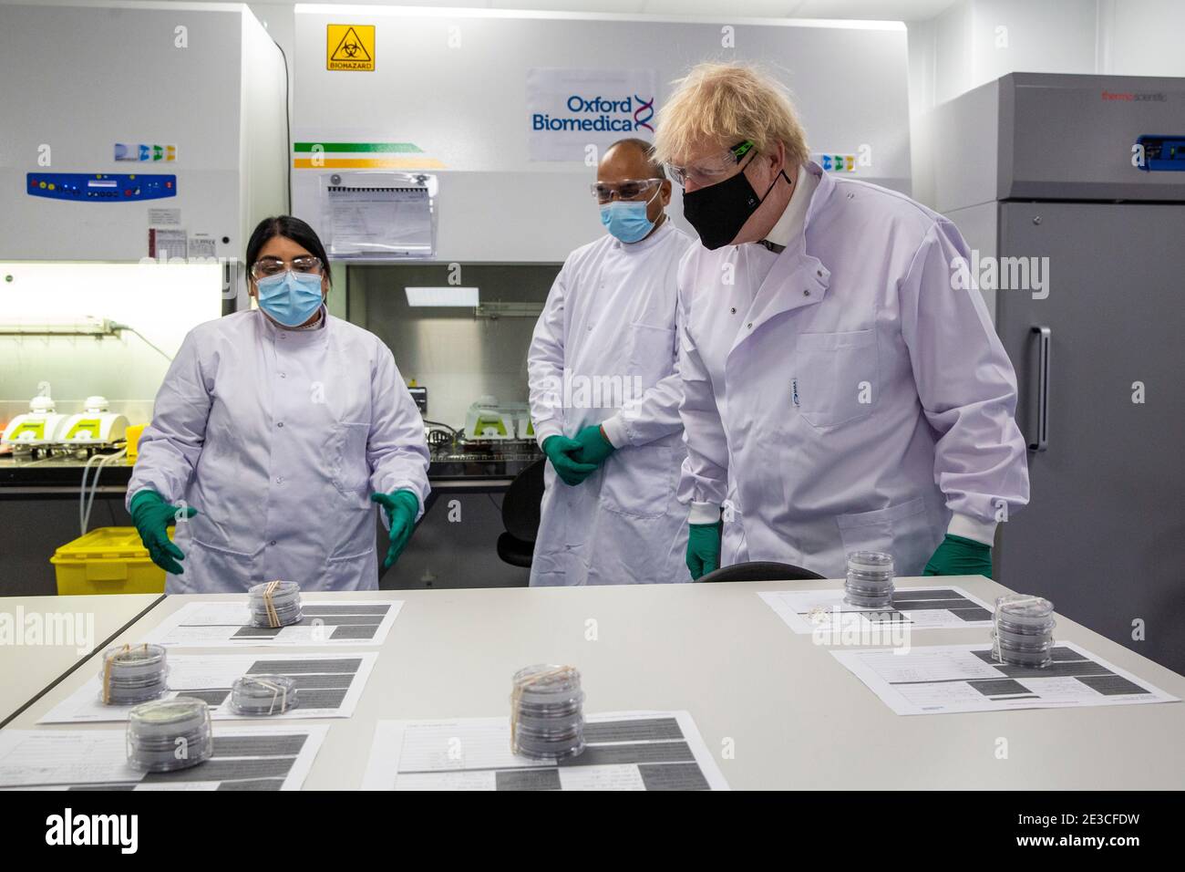 Le Premier ministre Boris Johnson s'entretient avec Dipesh Sonar (au centre) et Nisha Gill dans le laboratoire de contrôle de la qualité, où des lots de vaccins sont testés, lors d'une visite de l'usine de fabrication du vaccin Oxford/AstraZeneca à Oxford Biomedica dans l'Oxfordshire. Date de la photo: Lundi 18 janvier 2021. Banque D'Images