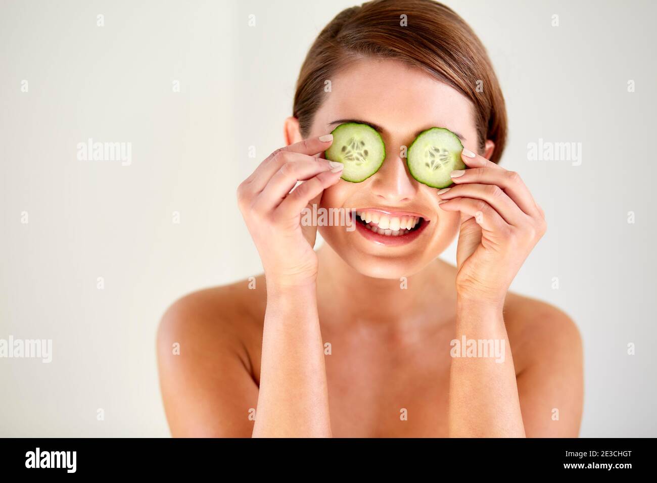 Femme avec le concombre sur les yeux pour atténuer les poches Banque D'Images
