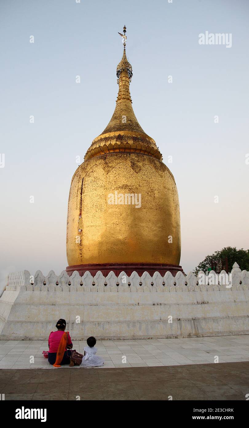 Mère et enfant priant au dôme doré du Bupaya Pagode Bagan Pagan Myanmar Birmanie Banque D'Images