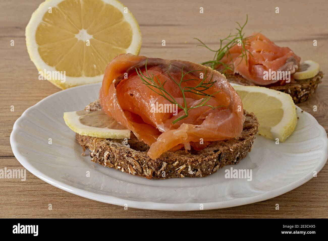 due fette di pane rustico con salmone affumicato con limone Banque D'Images