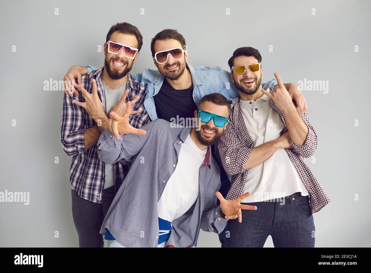 Groupe de jeunes amis en lunettes de soleil regardant l'appareil photo et poser pour une photo amusante Banque D'Images