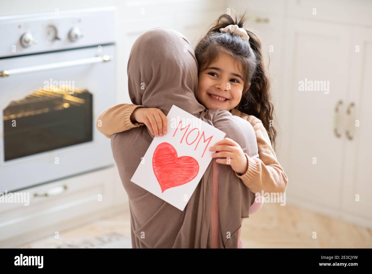 Petite Fille Tenant Une Carte De Voeux Pour La Fete Des Meres Et Embrassant Maman Musulmane Photo Stock Alamy Petite Fille Tenant Une Carte De Voeux Pour La Fete Des Meres Et Embrassant Maman Musulmane Photo Stock Alamy
