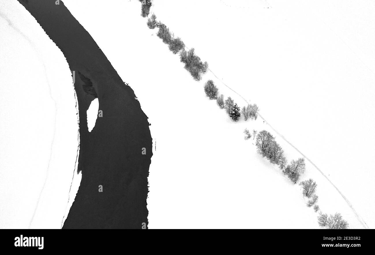 Schwangau, Allemagne. 18 janvier 2021. Les arbres et le Lech qui coule à travers le Forggensee se distinguent dans le paysage enneigé (vue aérienne avec un drone). Les arbres bordent la rive du lac en été. En hiver, le Forggensee, alimenté par le Lech, est drainé et le cours de la rivière devient visible. Credit: Karl-Josef Hildenbrand/dpa/Alay Live News Banque D'Images