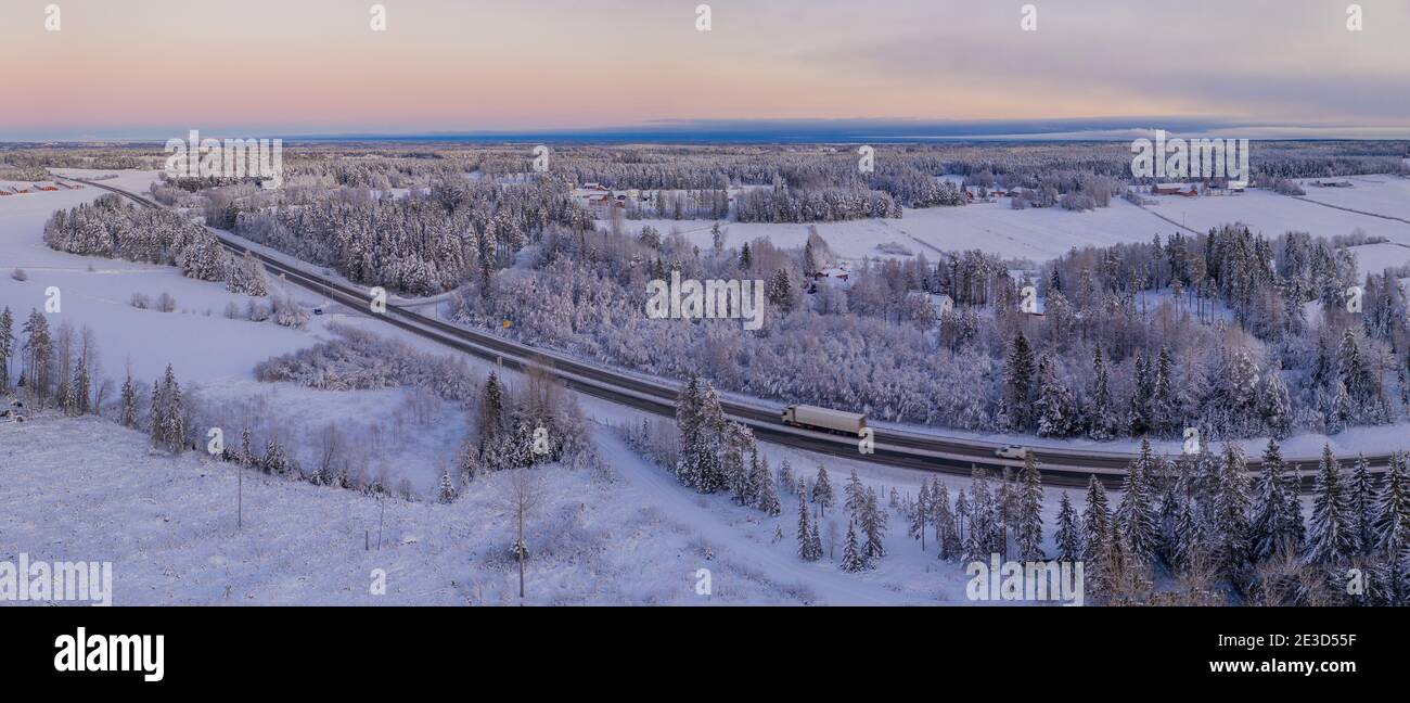 Spectaculaire photo aérienne d'hiver de la route européenne E4 près de la ville d'Umea. Pittoresque forêt de pins scandinaves surgelé, couverte de neige abondante. Banque D'Images