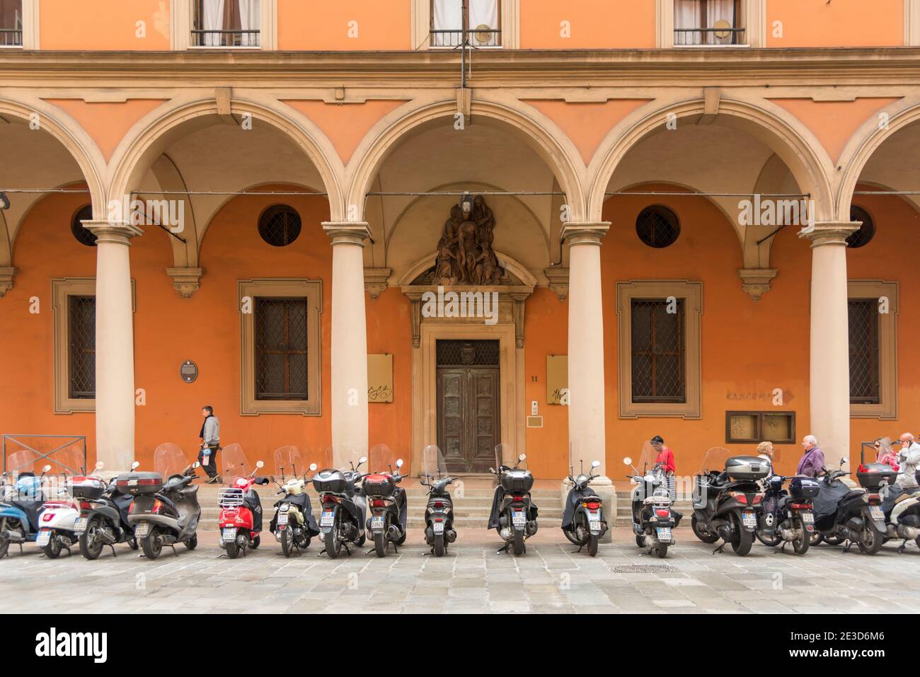 Une rangée de scooters ou de motos garés à l'extérieur Un bâtiment historique dans la ville italienne de Bologne Italie Banque D'Images